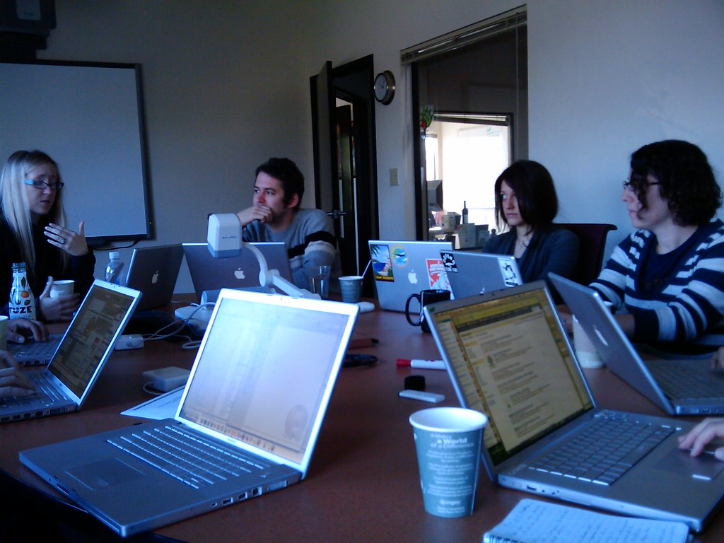 Team working on laptops around a meeting table